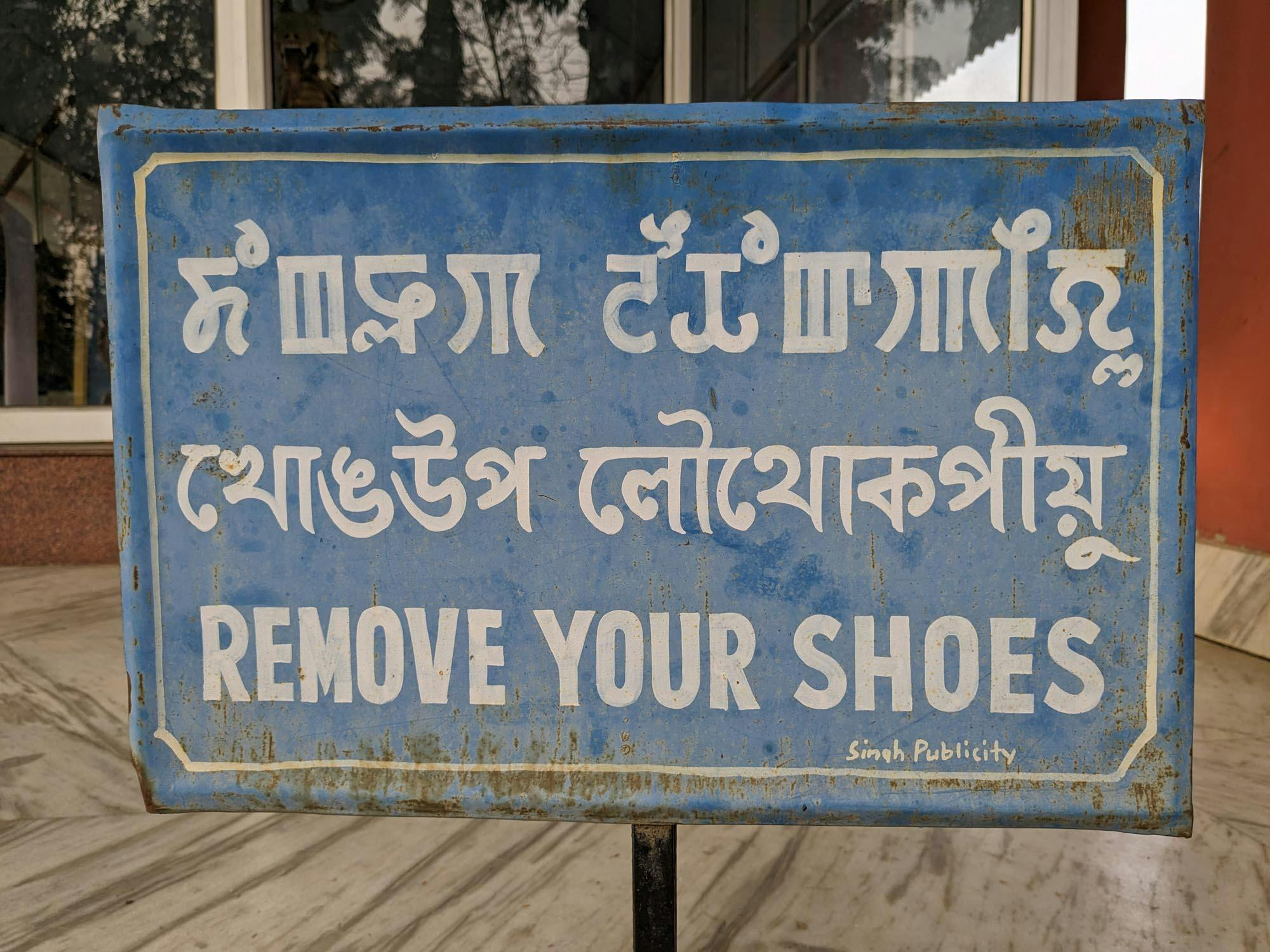 Sign outside a temple, with Meitei text in both scripts.